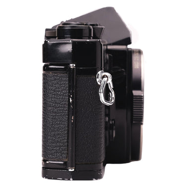 Olympus OM-1 black left side showing strap lug and edge paint wear