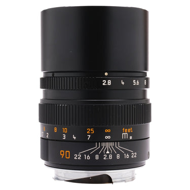 Leica 90mm f2.8 Elmarit-M lens front three-quarter view with aperture scale and built-in hood extended