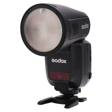 Godox V100 flash for Sony, front three-quarter view showing round flash head and fold-out stand foot