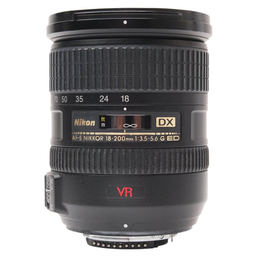 Nikon AF-S 18-200mm VR DX lens standing upright, front cap on top and F mount at base