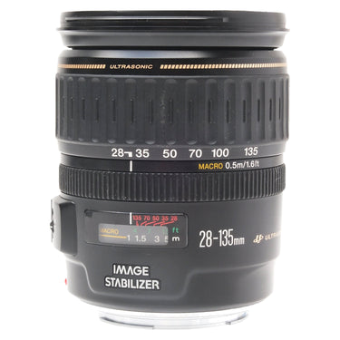 Canon EF 28-135mm IS USM zoom lens standing upright with front cap on, showing zoom scale and Image Stabilizer markings