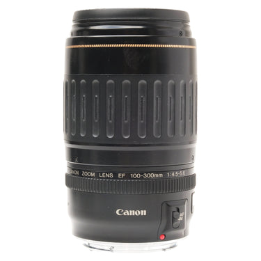 Canon EF 100-300mm USM lens standing upright with front cap and mount cap fitted