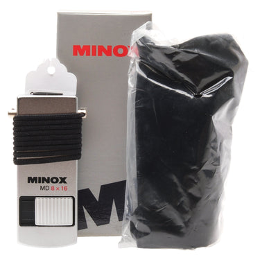 Minox MD 8x16 monocular with lanyard wound around the body, alongside its black pouch and original Minox box