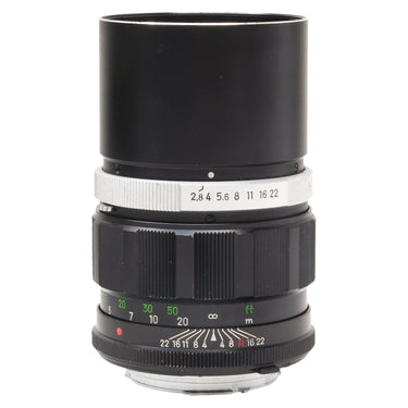 Minolta 135mm f2.8 MC Tele Rokkor-PF lens standing upright with built-in hood extended and aperture scale