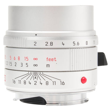 Leica 50mm f2 APO-Summicron-M silver lens front three-quarter view with aperture and depth-of-field scales