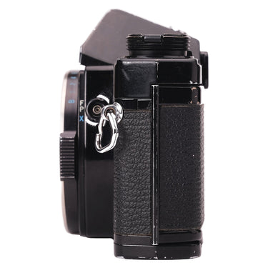 Olympus OM-1 black right side with lens, strap lug and sync socket