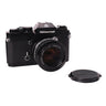Nikon Nikkormat EL front three-quarter view with Nikkor 50mm f1.4 lens and separate front lens cap