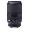 Tamron 18-300mm Di III-A VC VXD lens standing upright with front cap and hood on top, zoom ring and LOCK switch