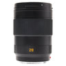 Leica 28mm f2 APO-Summicron-SL standing upright with bayonet hood mounted and focus ring visible